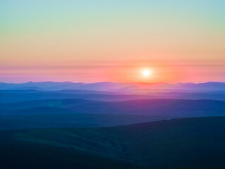 Fototapeta premium Beautiful sunset over layered mountain range creating a serene and tranquil landscape scene