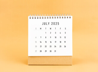 July 2025 desk calendar on yellow background, Front view.