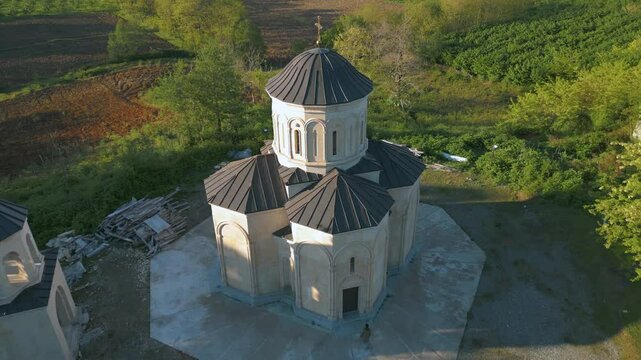 Aerial views showcase a stunning church surrounded by lush landscapes in Ajaria, Georgia. The architecture reflects local history and cultural significance, nestled in a picturesque setting.