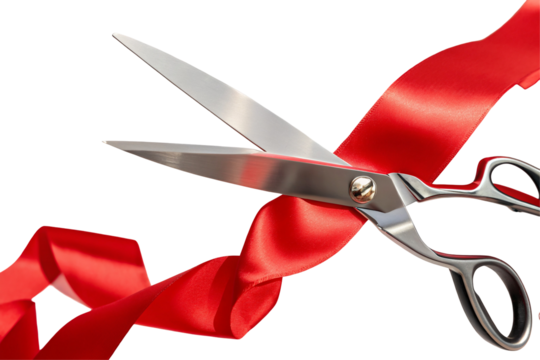 A close up shot of silver scissors cutting through a bright red ribbon against a black background space