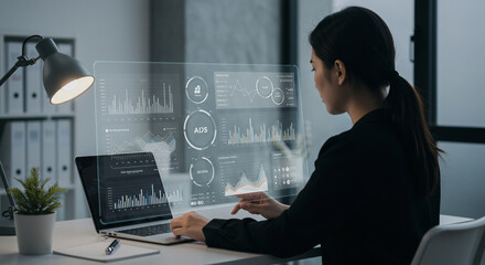 Businesswoman analyzing futuristic data dashboard at modern workplace