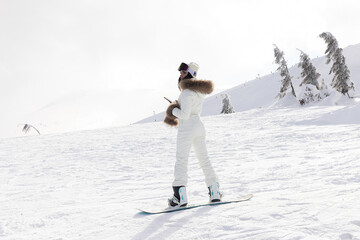 Woman snowboarder on the slopes on a frosty winter day