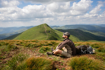 Man solo traveling backpacker hiking in scandinavian mountains