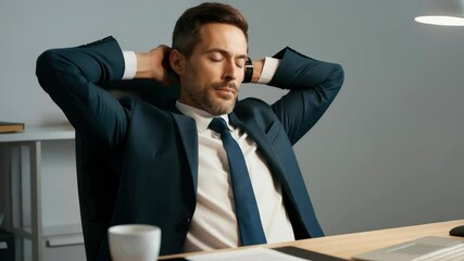 Businessman in suit relaxing at desk with coffee