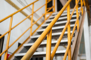 Banister handrail with yellow painting of stairway platform at the factory place. Industrial...