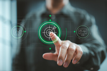 Man pointing at digital target icon with futuristic interface displaying performance metrics and dashboards.
