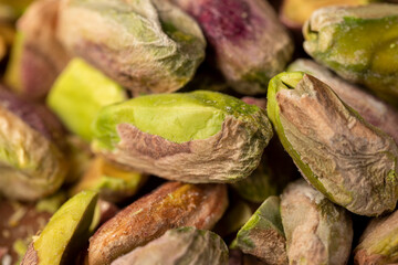 crunchy nuts, pistachios without shells, cut into pieces on a board