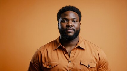 Obraz premium Plus size African man plain orange background, looking proud