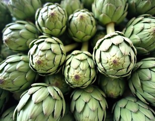 Obraz premium Close-up of fresh artichokes. Green vegetables in pile. Healthy food, vegetarian diet, organic farming, eco-friendly concept. Natural ingredients for cooking, healthy eating. Diet, closeup photo.