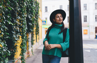 Stylish brunette woman, 30, walks while texting on her smartphone, showcasing seamless tech integration and real-time digital communication in motion.