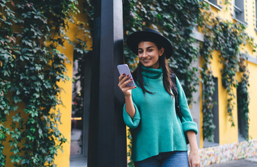 Focused brunette woman, 30, checks her smartphone outdoors, representing mindfulness in digital...