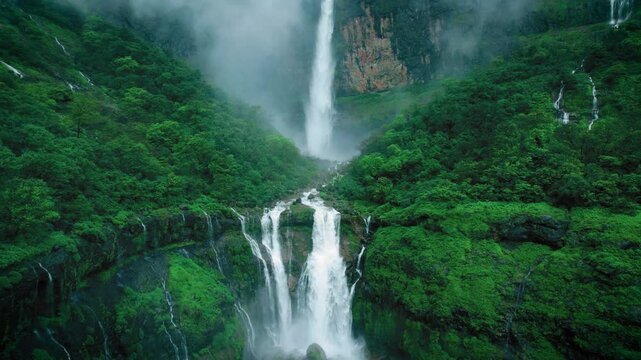 4K Aerial shot of mesmerising Nanemachi waterfall falling from cliff in Sahyadri hills during monsoon season at Maharashtra, India. Drone view of powerful waterfall in lush green forest landscape. 