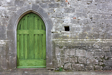 Small green back door of a gothic church