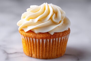 Close-up of a vanilla cupcake with swirled frosting.