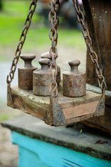 Close-up view highlights the textured wood and rusted chains of an antique balance, suggesting a bygone era of trade and measurement.