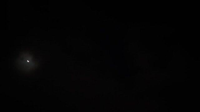Completely black sky except for the clearing where the moon illuminates it
