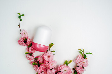 Deodorant bottles and flowers on white background. Personal care product. Cleanliness and freshness