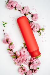 Shampoo, hair conditioner in a red jar on a white background. Mockup, space for text. Sakura...