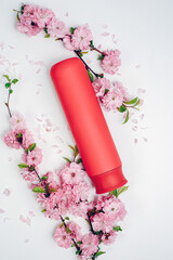 Shampoo, hair conditioner in a red jar on a white background. Mockup, space for text. Sakura...