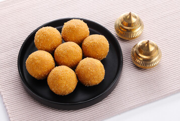 Indian traditional sweet called Besan Laddu or Besan Laddoo serve in plate isolated on matt 