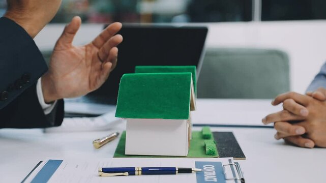 Lawsuits against Real estate agent and realtor general liability insurance businessman professional discussing and consultant with house toy model building before sign a contract with law concept