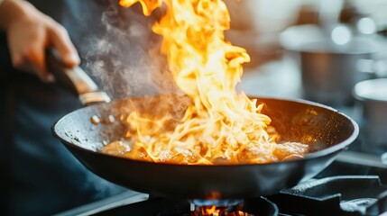A dynamic image of flames erupting from a frying pan, showcasing the excitement of cooking and the art of culinary preparation with a focus on the intensity of heat and flavor.