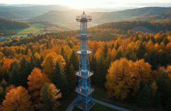 Aerial drone photo of Iwkowa village Brzesko Poland with observation tower. Autumn scenery. Forest trees in yellow, green and orange. Mountain hills, travel and tourism landscape.