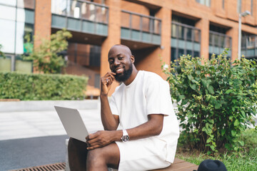 Smiling remote worker embraces creative moment, merging digital tools and positive attitude in a flexible freelance routine outdoors.