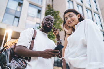 Focused young man checks smartphone outdoors, representing mindfulness in digital consumption, information access and mobile technology as integral part of daily flow.