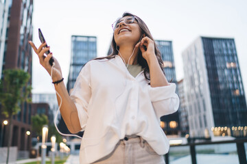 Stylish young woman walks while texting on smartphone, showing seamless tech integration, mobile...