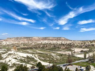 Obraz premium Panoramic view of natural rock formation, fairy chimneys of Cappadocia, Goreme, Turkiye on a beautiful spring blue sky day