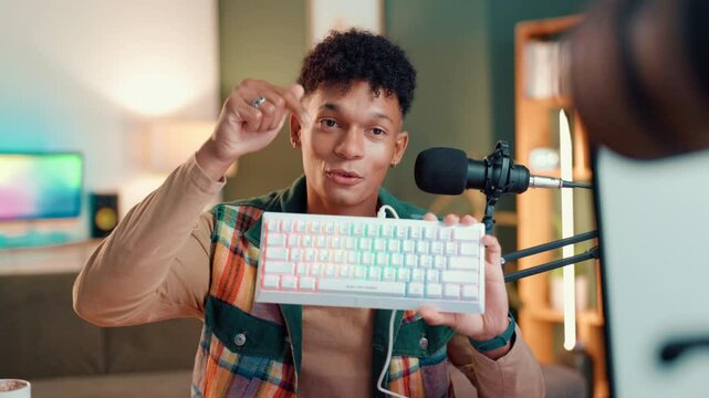 Feedback, live streaming and man with keyboard for review, opinion or demonstration for content creation. Talking, product promotion and male gaming influencer with tech for vlogging on social media.