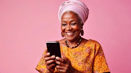 Elegant elderly african american woman wearing traditional clothing smiles while using a smartphone isolated on vibrant pink studio backdrop, enjoying modern technology and communication - Powered by Adobe