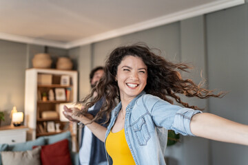 Happy couple dancing and having fun at home