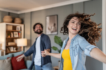 Happy couple dancing and having fun at home