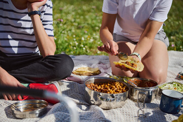 Outdoor Picnic Scene Featuring a Family Sharing a Meal of Tacos in a Natural Setting