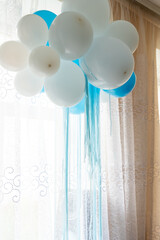 Decorative blue and white balloons hanging indoors for celebration