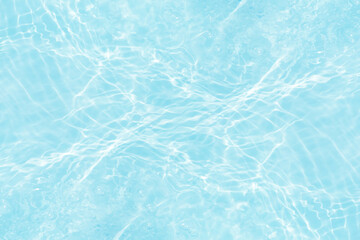 Blue water with ripples on the surface. Defocus blurred transparent blue colored clear calm water surface texture with splashes and bubbles. Water waves with shining pattern texture background.