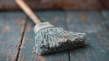 A close-up of an aged mop on a rustic wooden floor, showcasing the everyday simplicity of cleaning tools in a vintage context, evoking a sense of nostalgia and functionality.