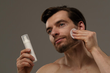 Man Applying Skincare Product to Enhance Facial Health