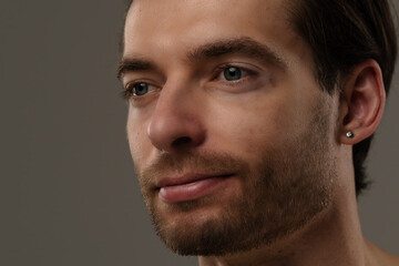 Naklejka premium Portrait of a Man with Short Hair and Earrings