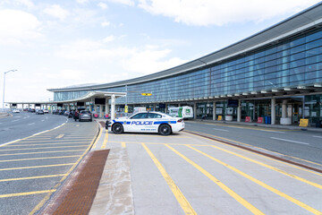 Naklejka premium Mississauga, Ontario, Canada - May 7, 2025: Police cars parked at the passenger drop-off area in Pearson International Airport in Mississauga, Ontario, Canada.