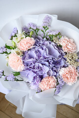 Delicate bouquet with hydrangea, lisianthus, and carnations in soft lavender and pink tones, wrapped in white paper — perfect for weddings, gifts, or romantic decor.