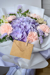 Delicate bouquet with hydrangea, lisianthus, and carnations in soft lavender and pink tones, wrapped in white paper — perfect for weddings, gifts, or romantic decor.Bouquet with envelope
