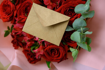 Romantic bouquet with red roses and pink alstroemerias wrapped in soft pink paper — ideal for...