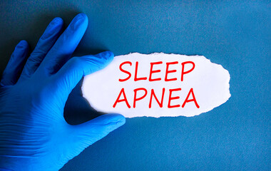 Sleep apnea symbol. Concept words Sleep apnea on beautiful white paper. Doctor's hand in blue...