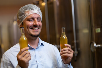 winemaker : winemaker hold bottle of wine check process of make wine. Wooden wine barrels or cognac...