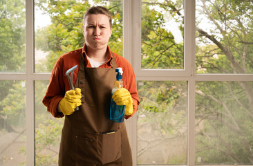 cleaning, housework and housekeeping concept. Young woman wearing apron with washer and spray...