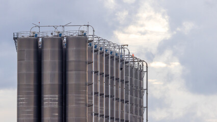 Row of large industrial silos for chemical petrochemical raw material storage, Storage silos in industrial modern industry, Industrial storage tank silos.