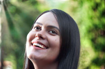 Close-Up of Smiling Woman Looking Up Outdoors